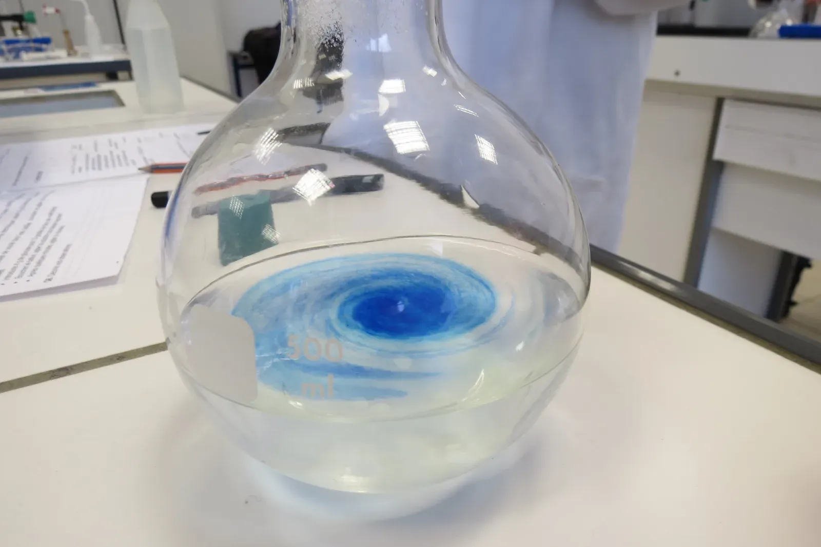 Methylenblau-Lösung verteilt sich in einem Laborkolben
